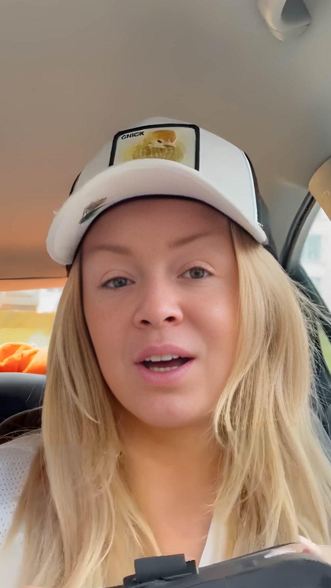 Kvinna med keps sitter i sin bil och berättar om sina erfarenheter av Imvi.